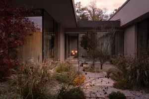 Modern residential architecture featuring concrete, glass, and stone materials.