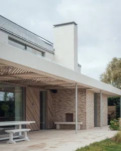 Modern residential exterior featuring a concrete roof, brick walls, and a fireplace.