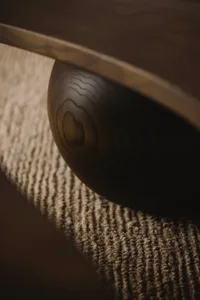 Close-up of a round wooden furniture carving on a textured carpet