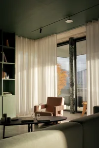 A cozy living room with textured fabrics, marble and glass elements