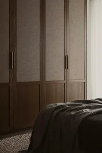 A minimalist bedroom featuring dark walls, wood detailing, and fabric textiles