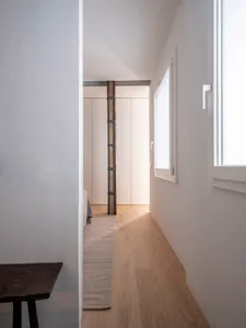 Minimalist bedroom featuring wood flooring and wooden furniture.
