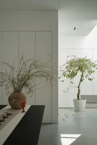 A minimalist interior with plaster walls and warm, ambient lighting fixtures.