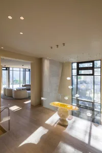 Modern minimalist living room with wooden flooring and large windows.