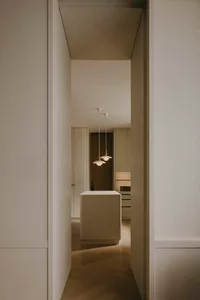 極簡設計的走廊，搭配木地板、吊燈與自然木質家具。