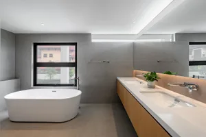 Modern bathroom with concrete walls and a large freestanding bathtub.