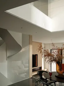 Modern interior featuring a glass staircase and minimalist design elements.