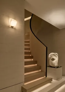 Modern interior staircase with wooden treads and a sleek, curved railing.