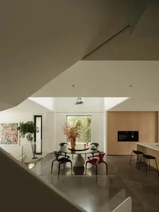 A modern kitchen with marble countertops, glass decor, and botanical elements.