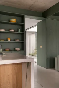 A modern kitchen interior with white marble countertops and wooden accents