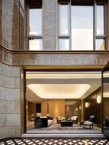 Modern lobby with concrete walls, large windows, and comfortable seating.