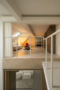 A contemporary living room featuring marble flooring, leather furniture, metal accents, and glass elements.