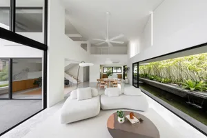 Modern minimalist living room featuring white furnishings and concrete elements.