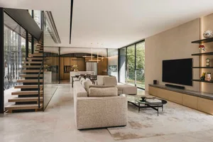 A modern minimalist living room features glass walls, wooden flooring, and marble accents.