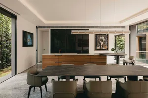 Modern residential interior featuring an open-plan living, dining, and kitchen area with marble countertops, wooden cabinets,