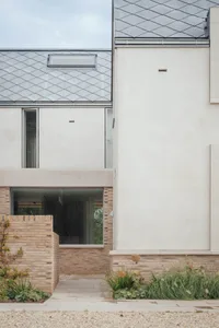 A minimalist building exterior with stone and glass materials.