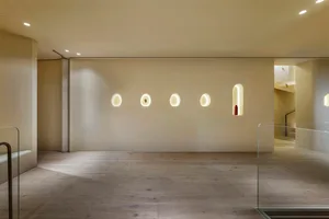 A minimalist interior design featuring wooden elements, modern lighting fixtures, and a clean, uncluttered space.