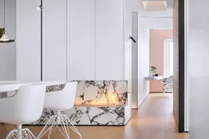 Modern, minimalist living room with marble accents and white furniture.