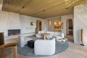 A modern living room featuring a textured fabric sofa and cushioned seating area.