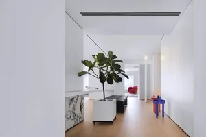 Modern living room with white marble accents and hardwood flooring