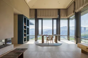 A modern living room featuring wooden furniture and a scenic view of mountains.