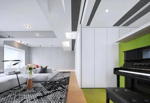 A minimalist living room with white and grey furniture and green plants.