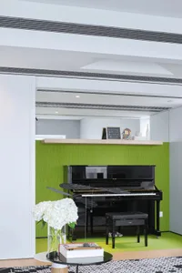 A modern music room featuring a black Yamaha piano, a black piano bench, and a black and white rug with white flowers in a va