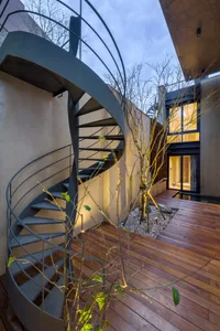 An exterior view of a modern spiral staircase made of metal.