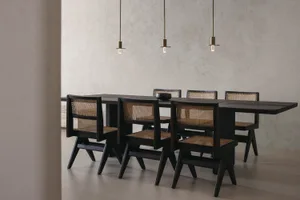Modern industrial dining room with black and wood furniture, and hanging pendant lights.