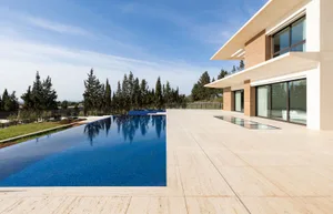 Modern home exterior featuring large glass windows and concrete walls.