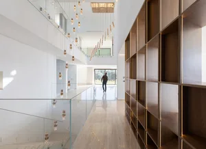 Modern interior with glass walls, wooden shelves, and minimalist design.