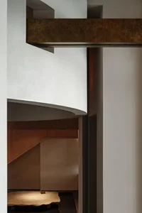 A modern interior design featuring a wooden bridge connecting two levels of a house.