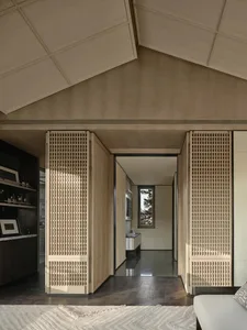 A contemporary living room featuring wooden paneling and a geometric ceiling design.
