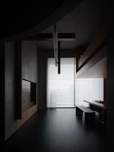 A minimalist interior design featuring concrete walls and large glass windows.