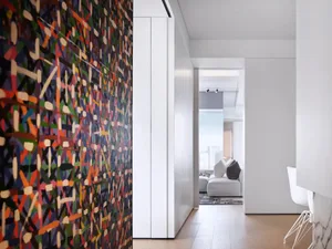 Modern minimalist living room with colorful abstract art on the wall and a white sofa.