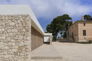 A modern residential exterior featuring stone and concrete materials.