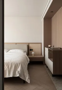 A minimalist bedroom featuring textured wood, woven cane, and soft textiles.