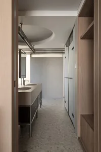 A minimalist bathroom featuring concrete materials and an industrial ceiling light.