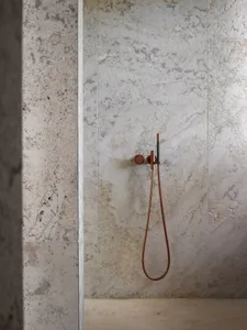Modern bathroom with marble floor tiles, metallic shower head, and minimalist design.