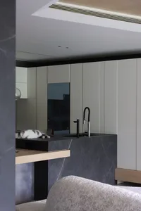 A modern kitchen with black and white marble countertops, featuring stainless steel appliances and modern fixtures.