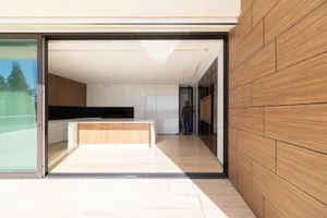 Modern residential kitchen with marble countertops and wooden flooring.