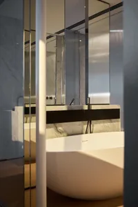 A modern bathroom featuring marble finishes and a freestanding bathtub.