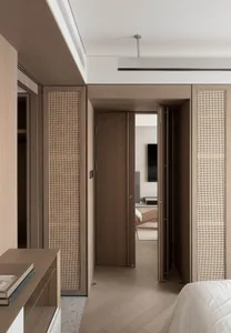 A modern minimalist bedroom featuring wood paneled walls and a sleek, uncluttered design.