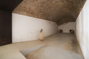 A minimalist concrete interior space with a smooth, unadorned wall and floor.