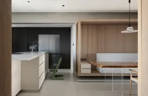 A modern minimalist kitchen featuring wooden elements, including a wooden dining table, chairs, and cabinetry, set against a 