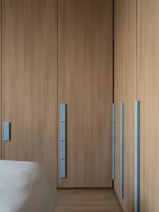 A modern minimalist bedroom featuring wooden furniture and paneling.