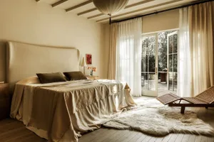 A minimalist bedroom featuring warm, natural fabrics and soft, neutral tones.
