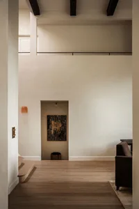 A minimalist interior design featuring wooden flooring and neutral tones.