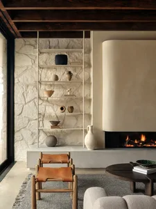A minimalist living room featuring a fireplace with a concrete and leather accent.