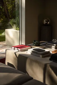 Living room with fabric couches and books on a table.
